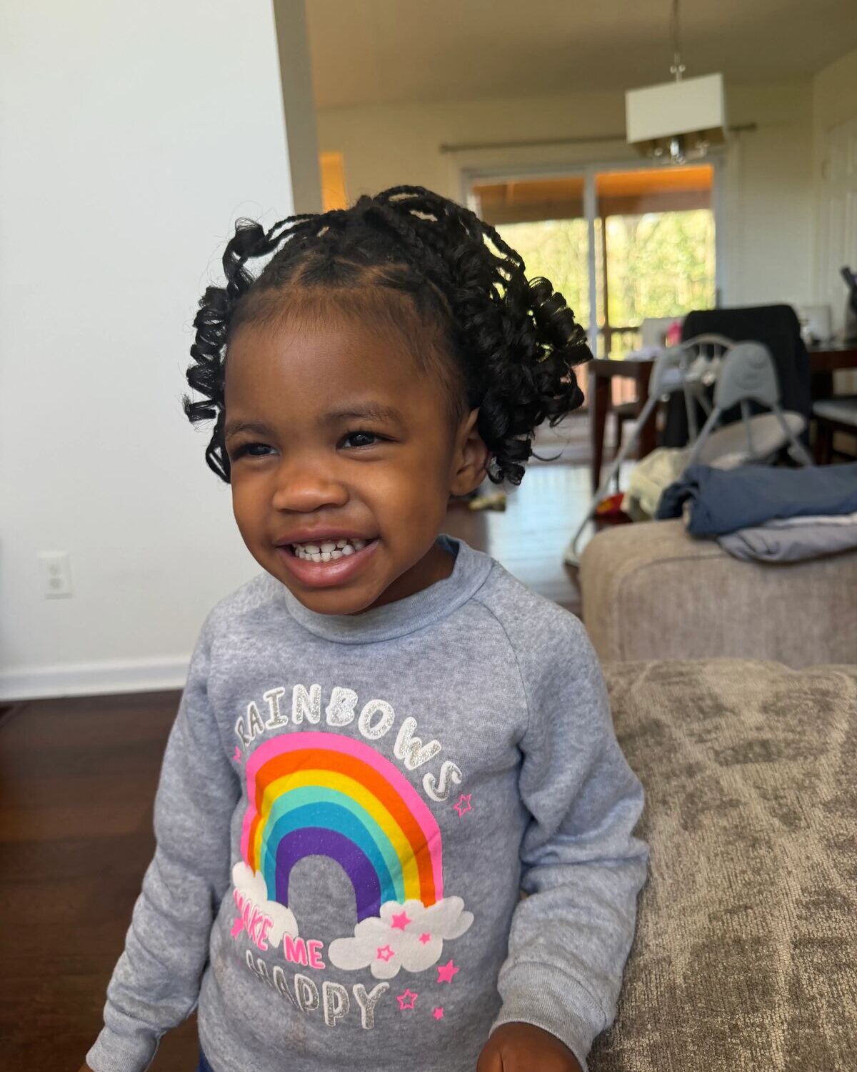 Smiling child with small braids and curly hair