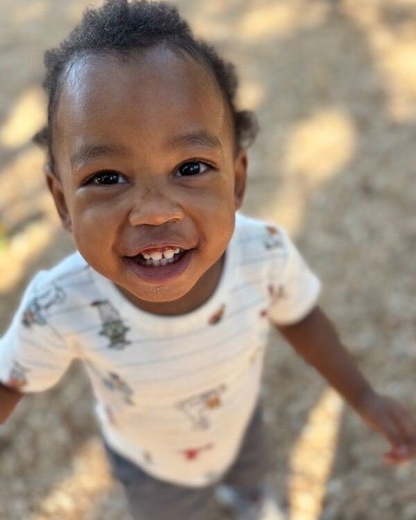 Smiling boy in a patterned shirt outdoors